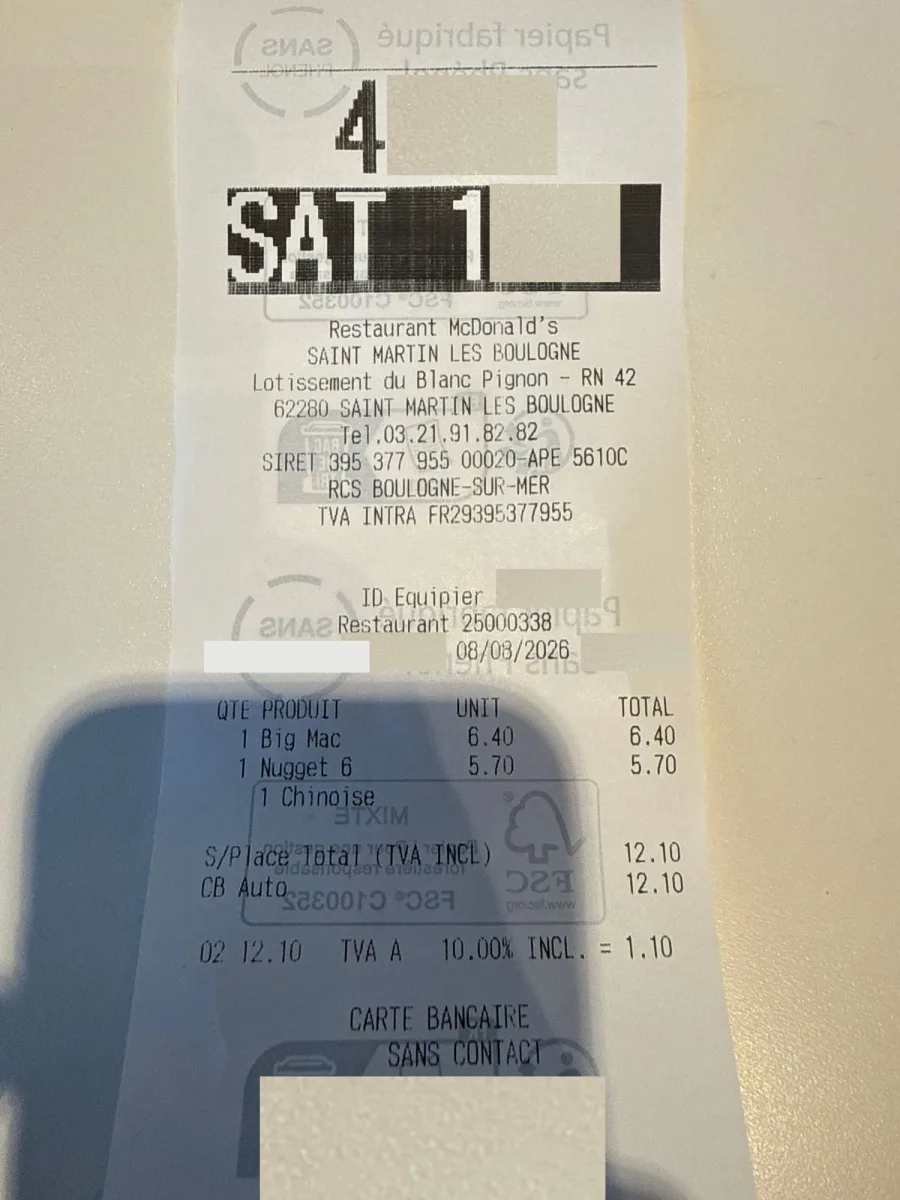 Till receipt from McDonald's Saint-Martin-Boulogne, 8 August 2026. Line items: 1 Big Mac 6.40, 1 Nugget 6 5.70, 1 Chinoise. S/Place Total (TVA INCL) 12.10. VAT line: 12.10, TVA A 10.00% INCL. = 1.10. Payment details and staff identifiers are redacted.